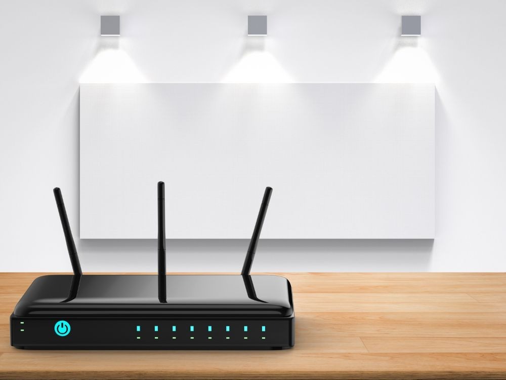 Um roteador moderno de cor preta está sobre uma mesa, com suas luzes de status acesas. O dispositivo de rede foca na infraestrutura de conexão para explicar a Diferença entre roteador e repetidor.